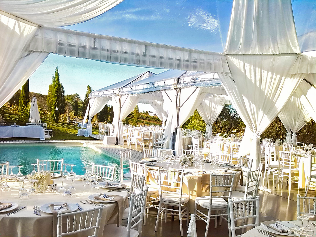 Elegant outdoor Italian catering table setup with white linens and floral centerpieces